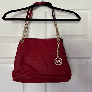 Michael Kors red leather purse with three inside pockets.
